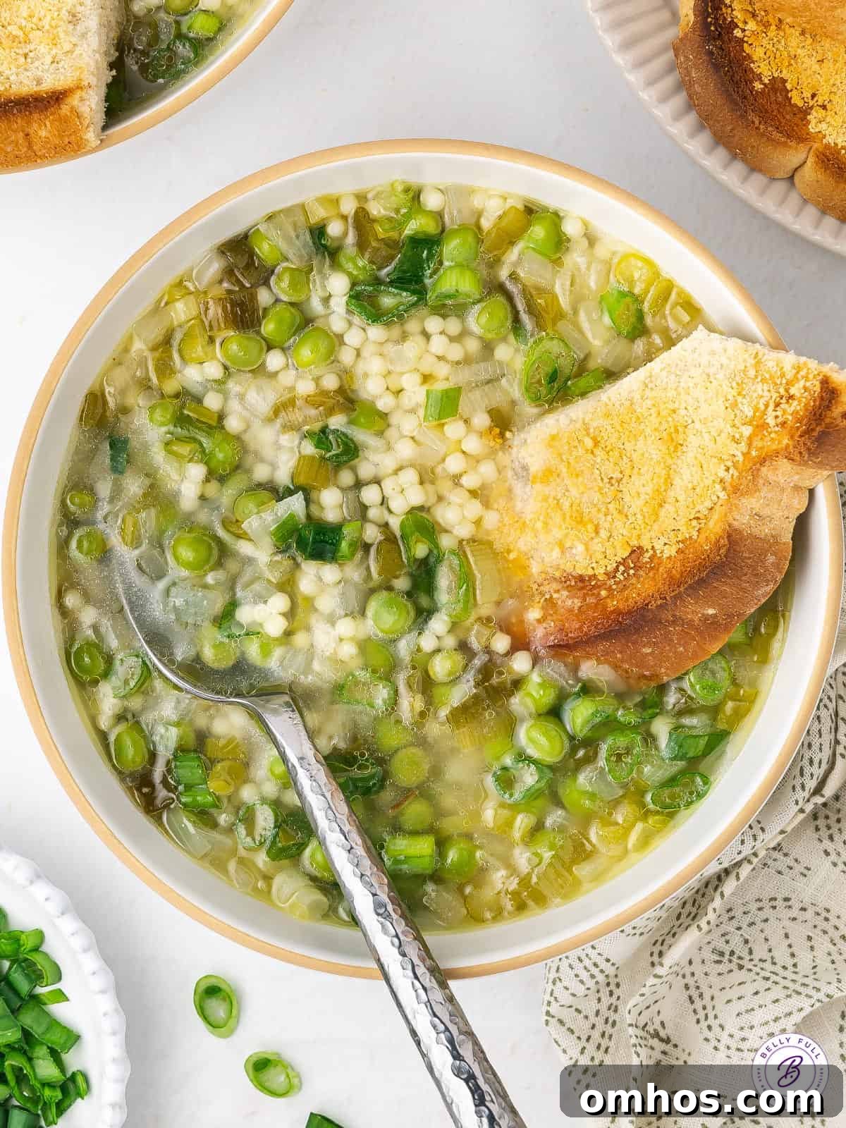 overhead bowl of onion and pea soup with toasted bread