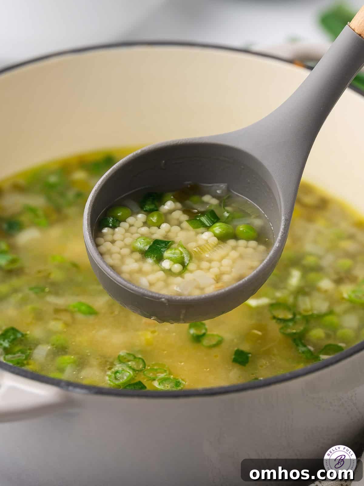 ladle of soup with peas and pasta