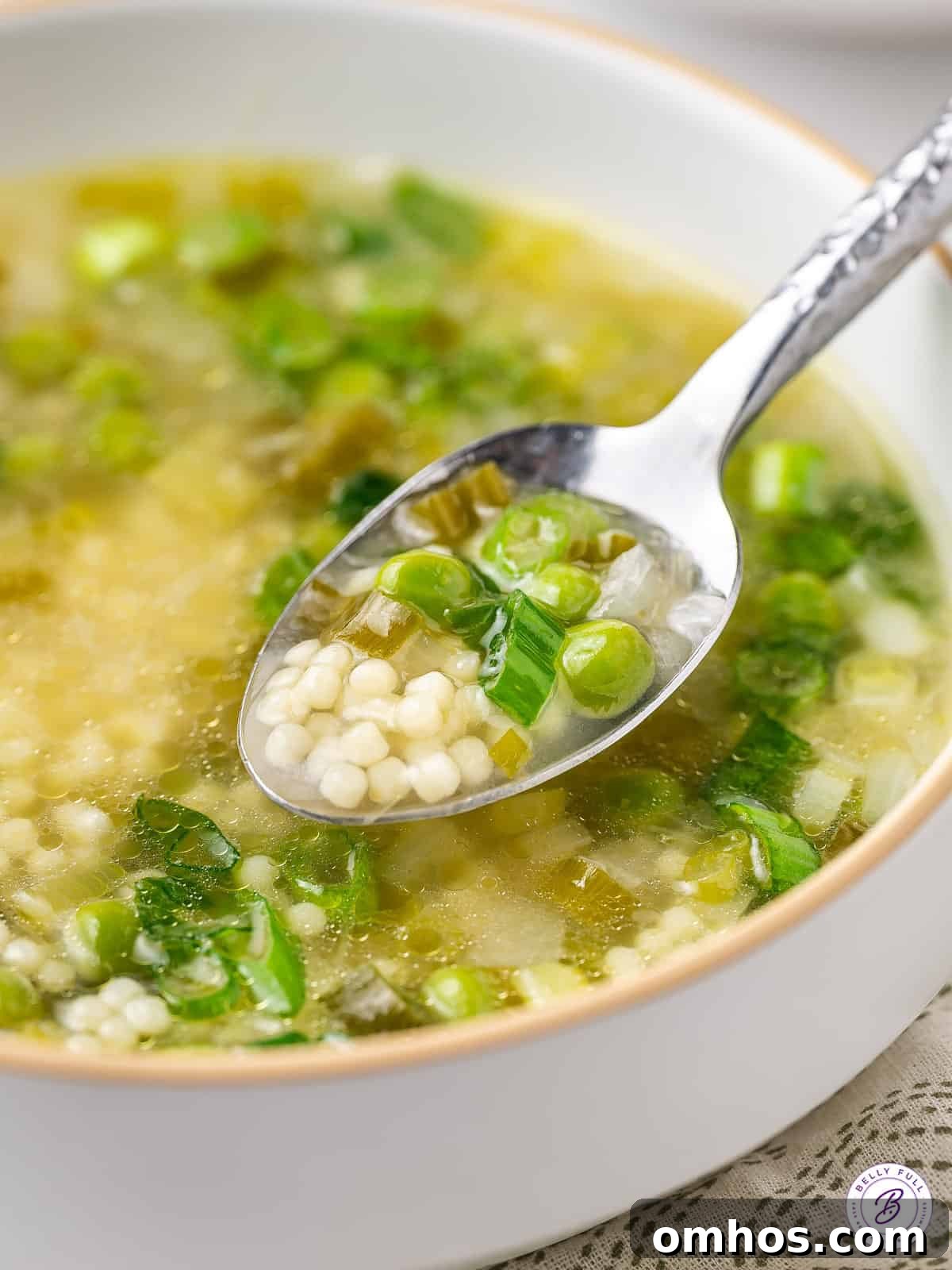 spoonful of soup with peas and tiny pasta