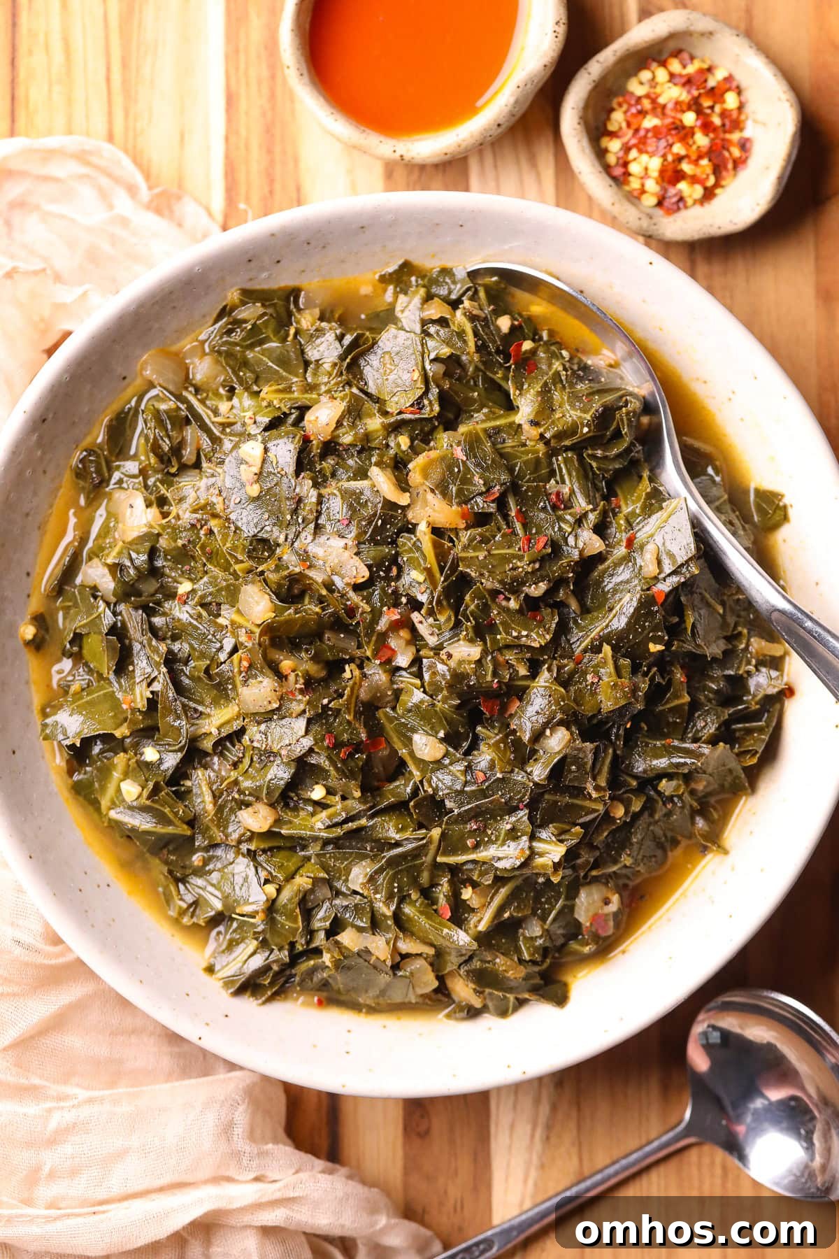 Vegan Southern Collard Greens Recipe 2 vegan southern collard greens in a white bowl sitting on a cutting board.