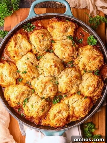 Catfish etouffee pot pie in a cast iron skillet, sitting on a wooden cutting board.
