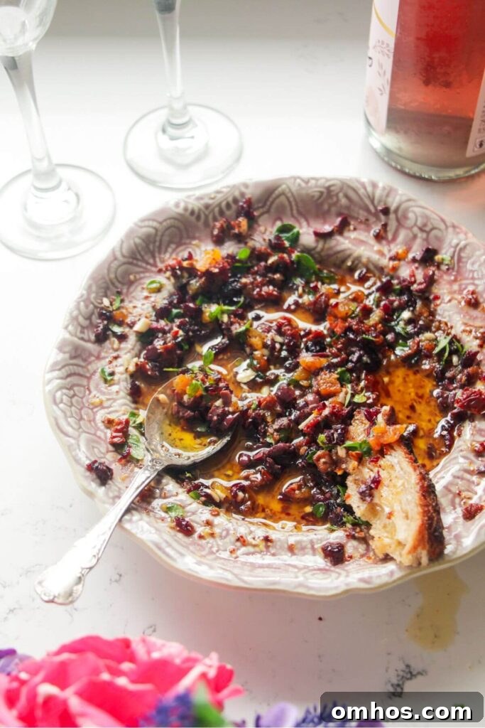 Date night bread dipping oil on a pink plate with a silver spoon.