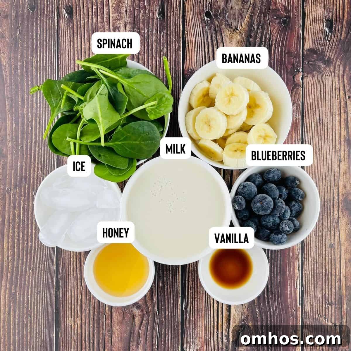 Spinach Banana Smoothie Recipe 2 The ingredients to make a healthy spinach smoothie measured out and placed on a wooden countertop.