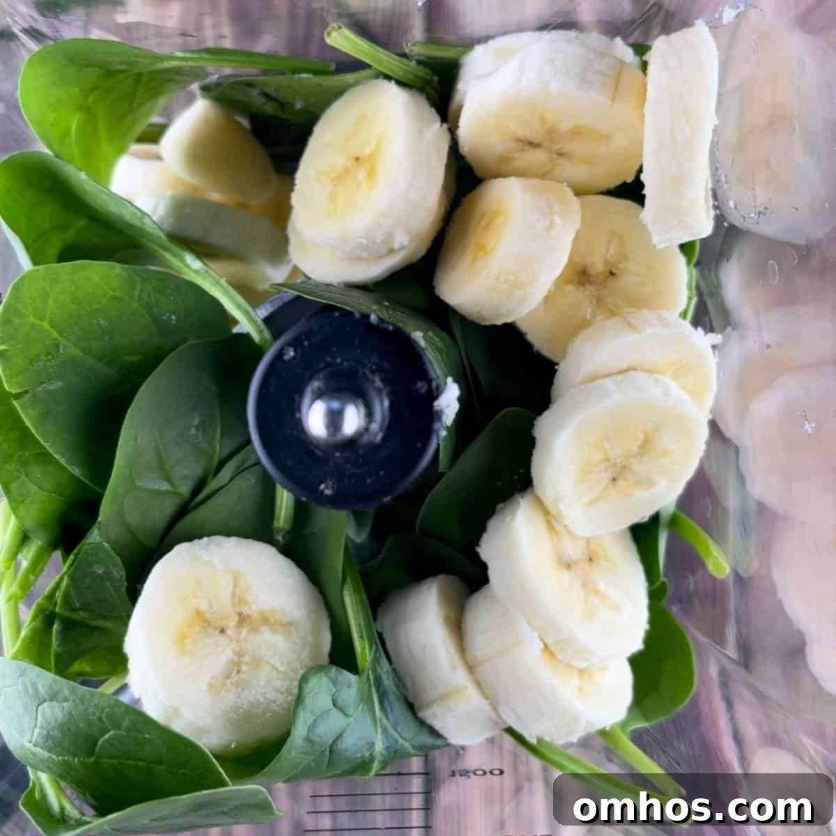 Spinach Banana Smoothie Recipe 3 Fresh spinach leaves and a sliced banana added to a blender.