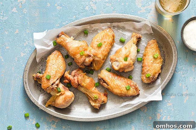 crispy wings on a silver plate with blue background