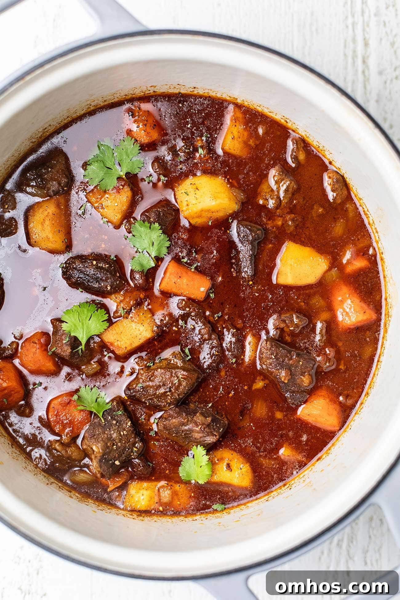 Moroccan Beef Tagine Recipe: Spiced Slow-Cooked Stew 10 A pot of Moroccan beef stew garnished with Italian parsley.