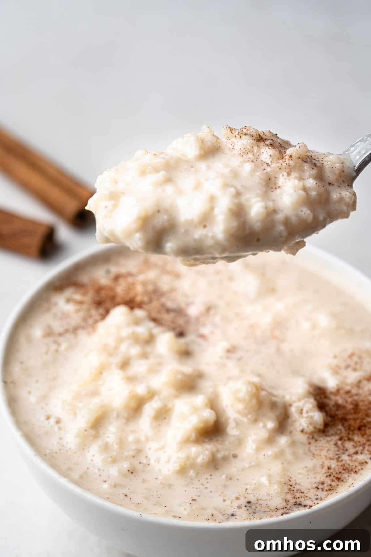 Creamy Instant Pot Arroz con Leche (Mexican Rice Pudding) 5 spoon scooping instant pot arroz con leche to show texture and consistency