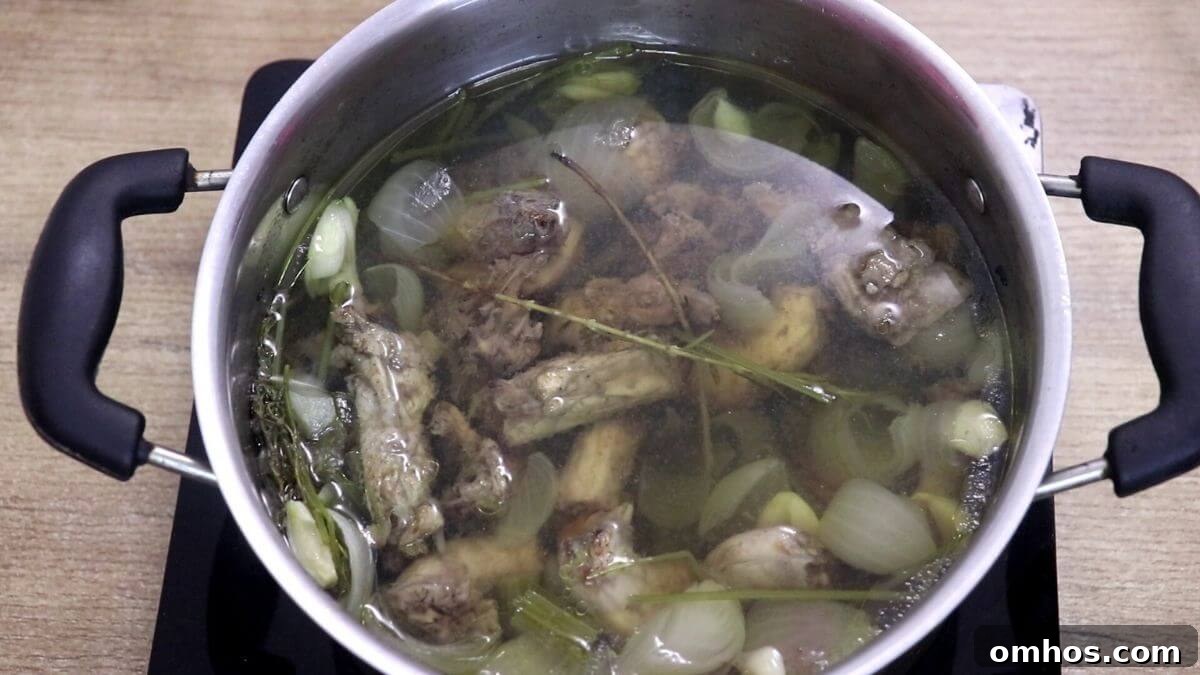 Chicken stock simmering slowly for two hours.