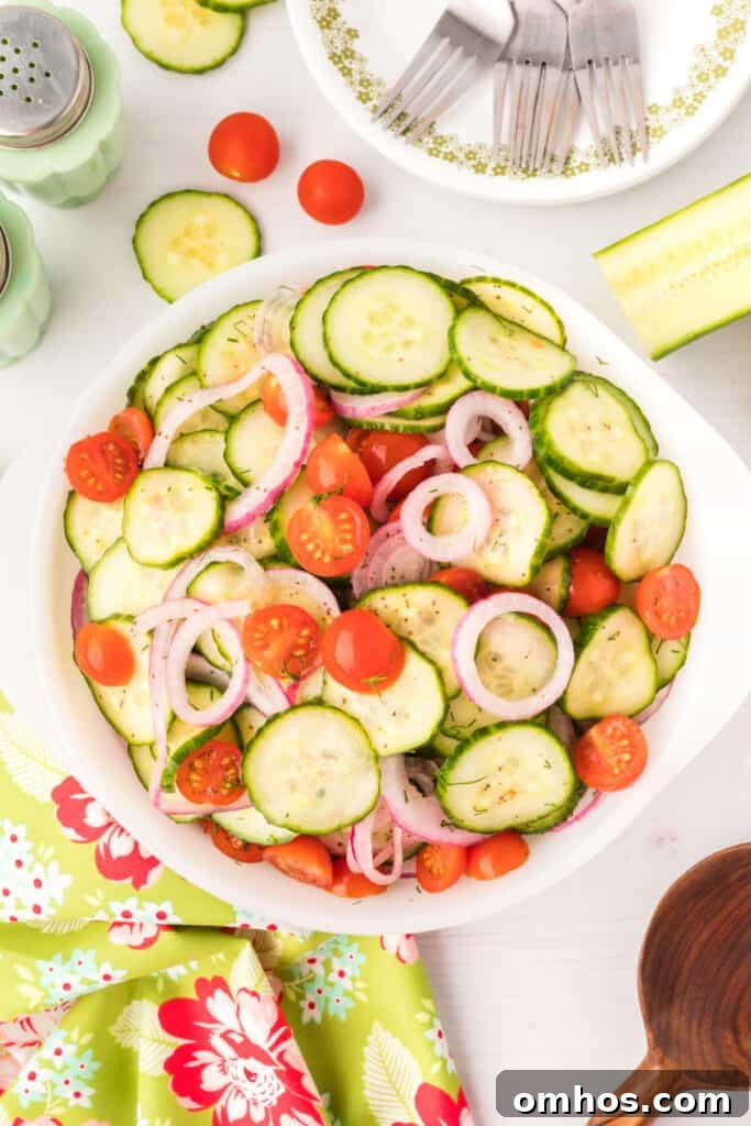Final salad served in a white bowl with cherry tomatoes and sliced cucumbers