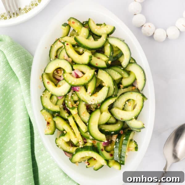 overhead view of cucumber salad in a serving dish with sesame seeds and red onion