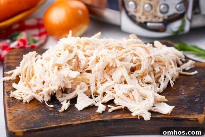Shredded chicken on a cutting board.