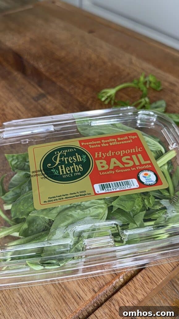 A container of fresh hydroponic basil labeled Florida Fresh Herbs on a wooden surface.