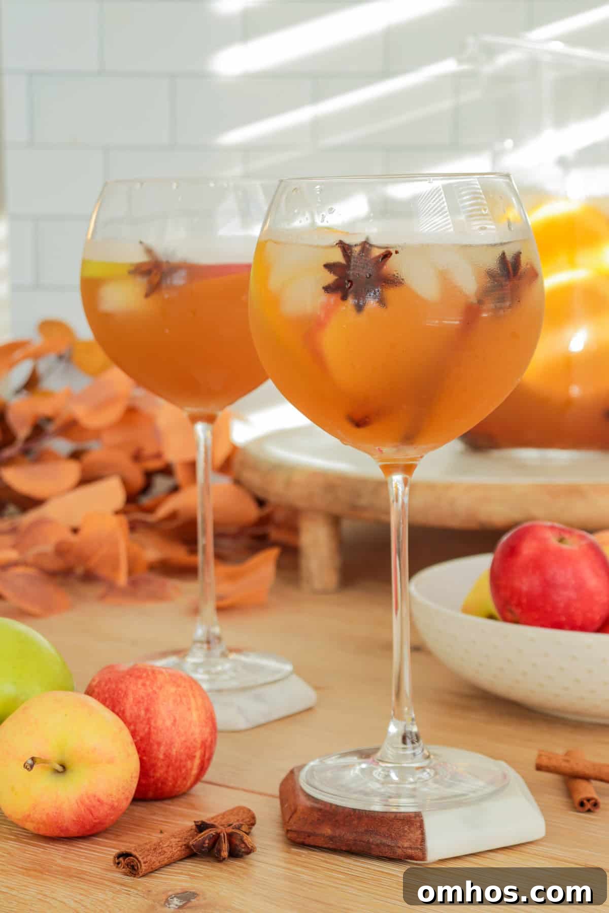 White wine fall sangria in a wine glass with star anise and apples.