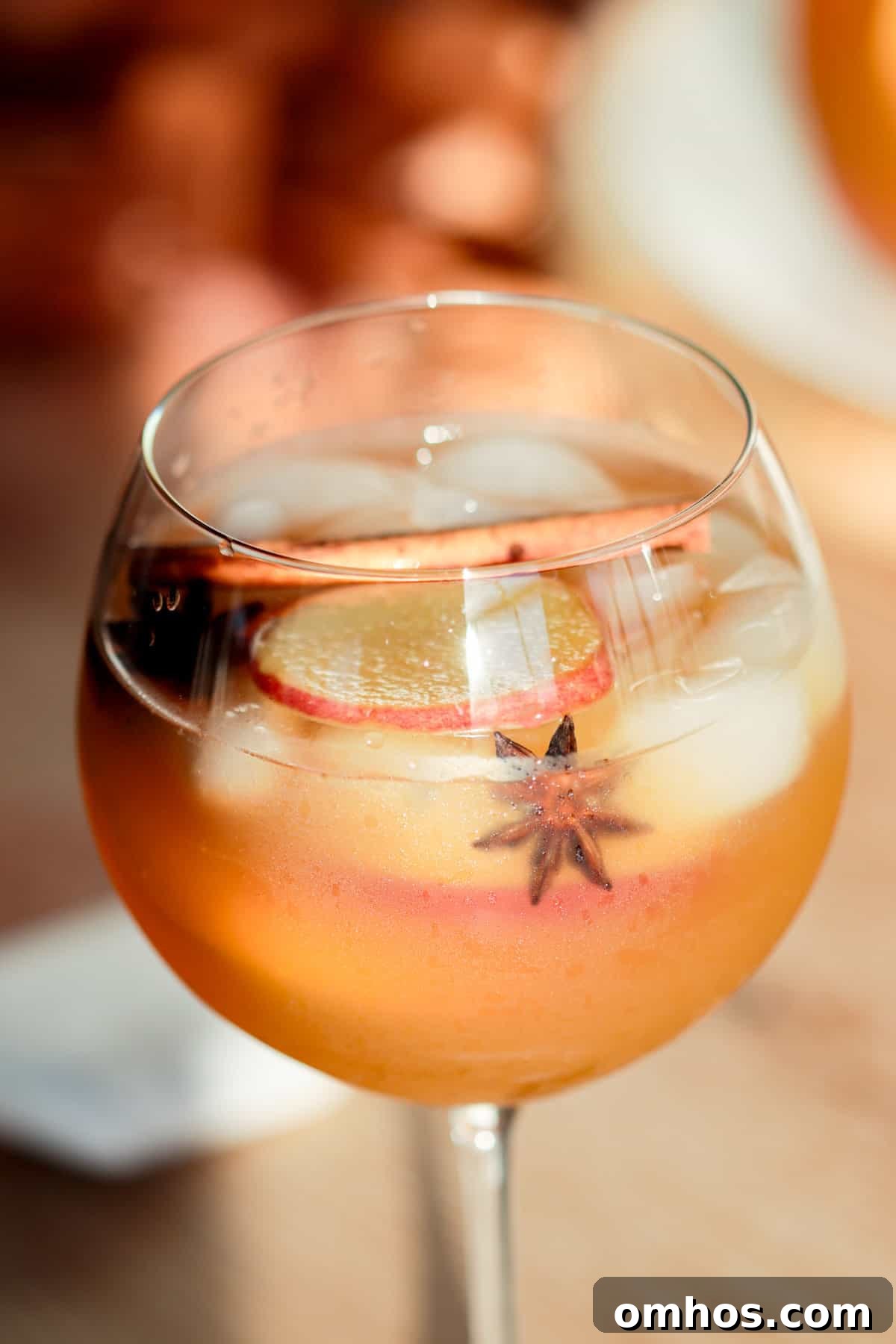 White wine apple cider sangria with cinnamon and spices in a glass.