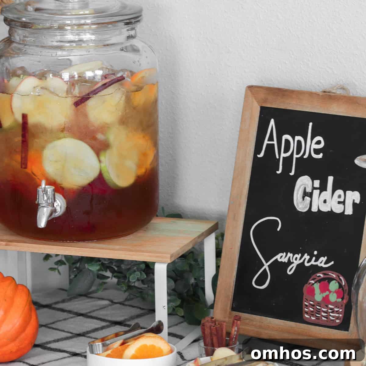 Apple cider sangria bar with various garnishes on a table.