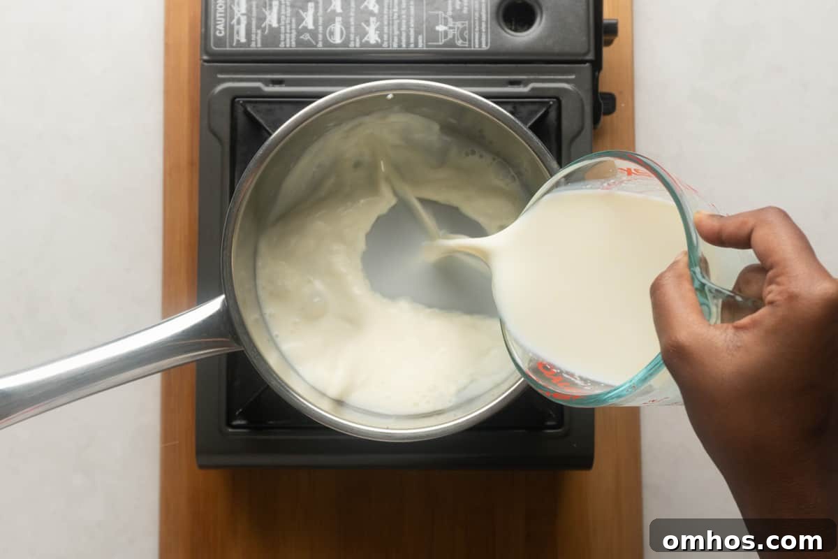 Picture showing milk being poured into a sauce pot to make eggnog
