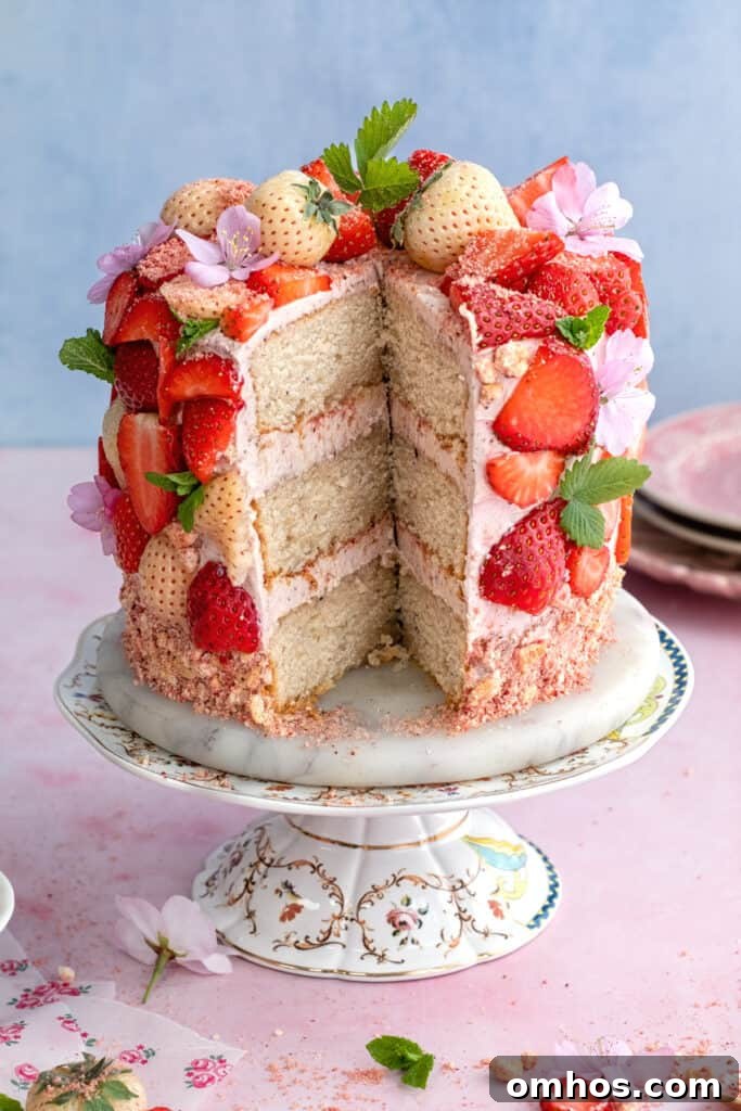 Fresh strawberry cake with slice cut out to show the layers