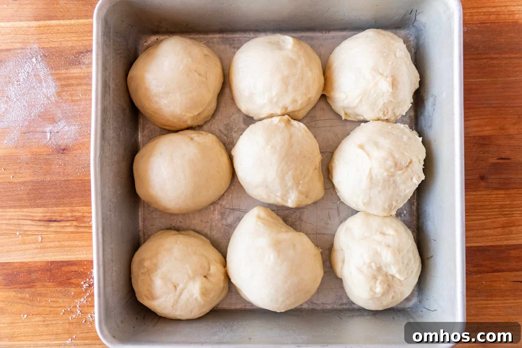 Fluffy Soft Dinner Rolls: Buttery Homemade Recipe 12 bread dough rolls in pan before second rise.