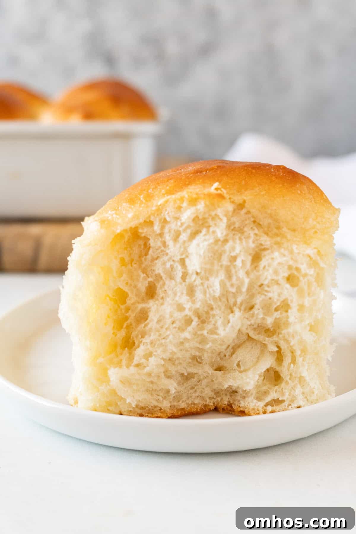 Fluffy Soft Dinner Rolls: Buttery Homemade Recipe 17 soft dinner roll on white plate.