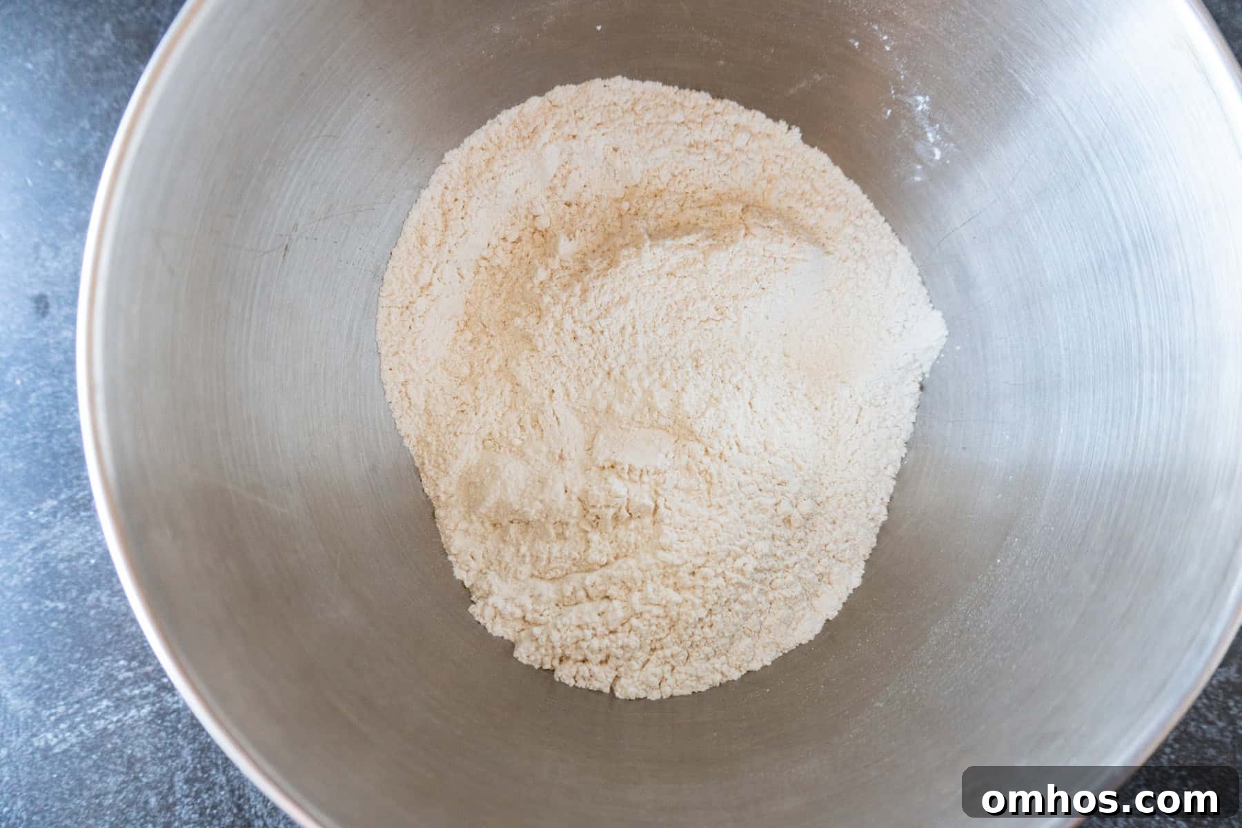 Fluffy Soft Dinner Rolls: Buttery Homemade Recipe 6 Flour, sugar, salt, and yeast mixed together in metal bowl.