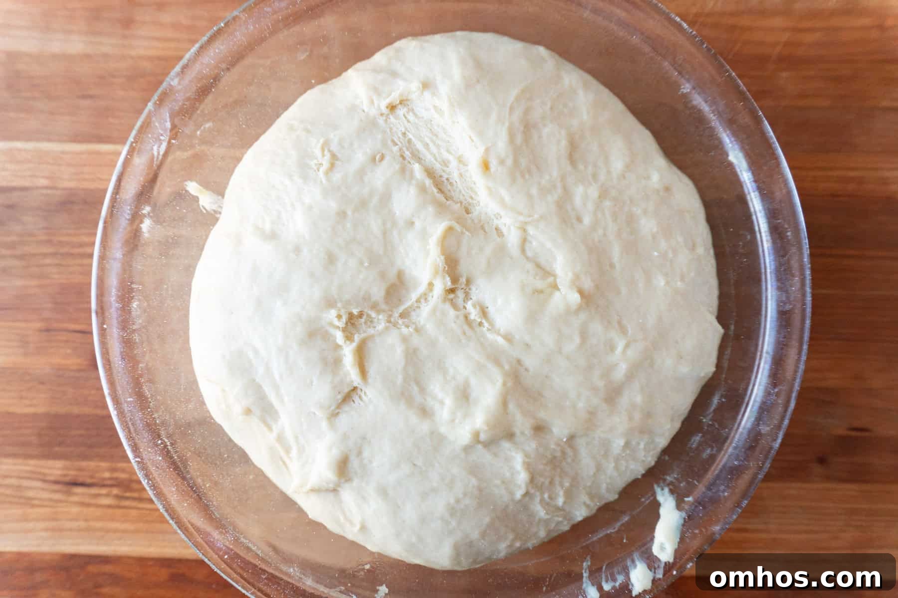 Fluffy Soft Dinner Rolls: Buttery Homemade Recipe 10 bread dough in glass bowl after first rise, doubled in size.