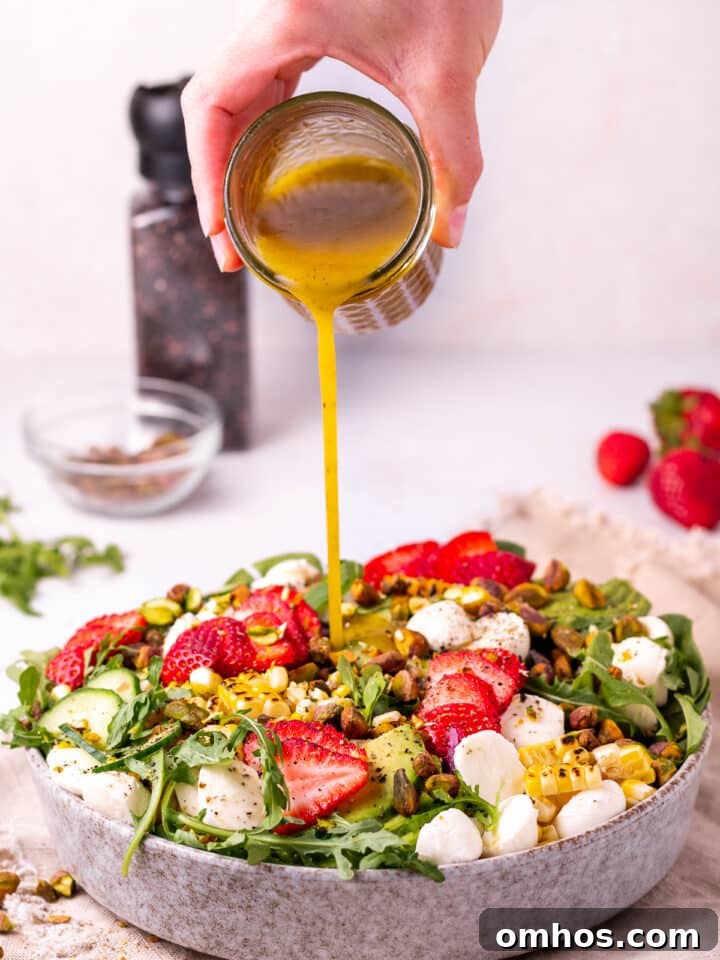 pouring white balsamic dressing on spinach arugula salad