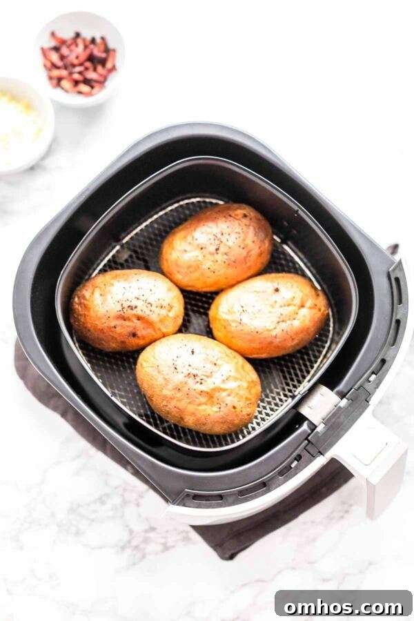 Four baked potatoes in an Air Fryer.