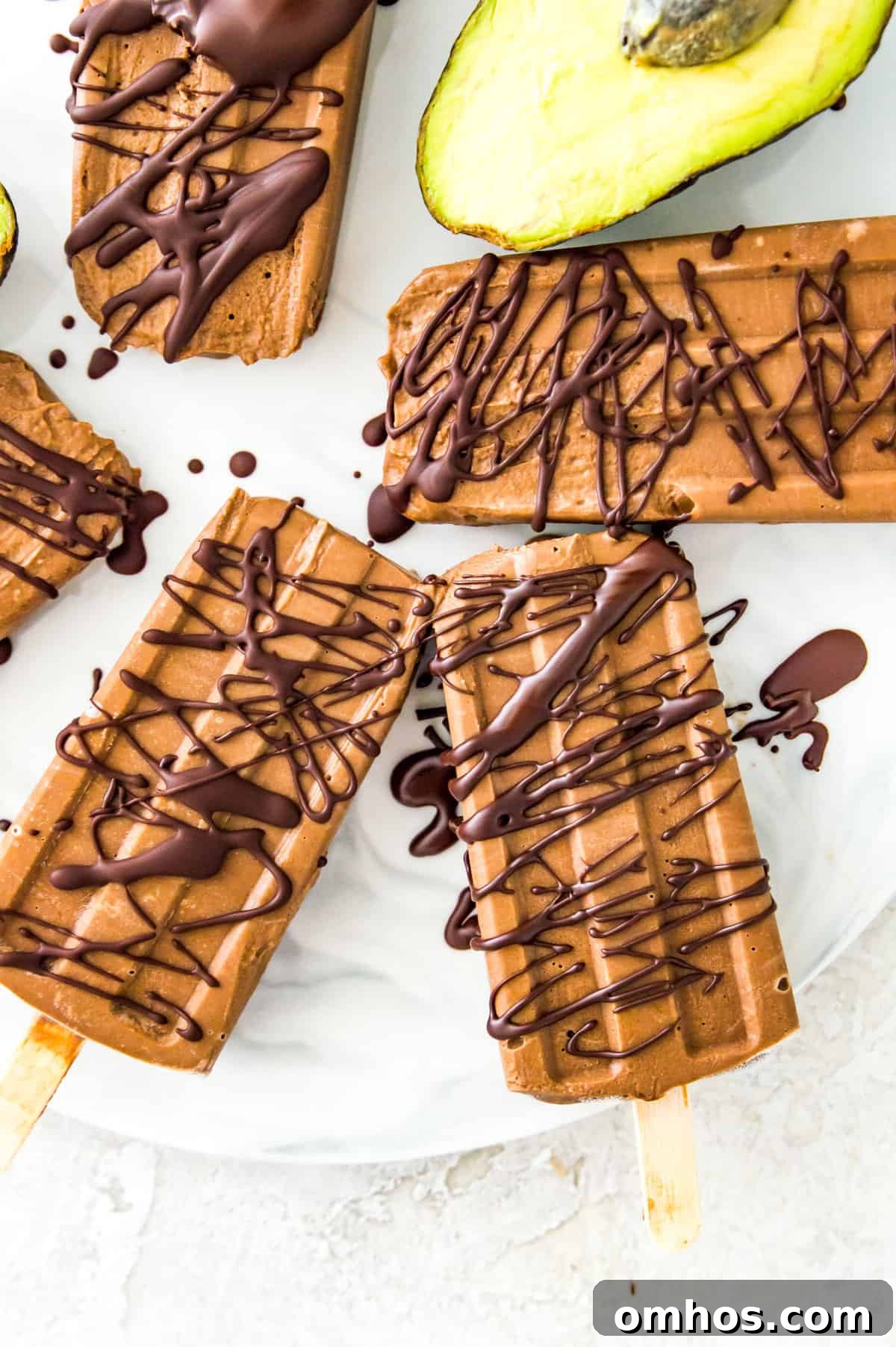 Chocolate popsicles drizzled in melted chocolate on a serving tray.