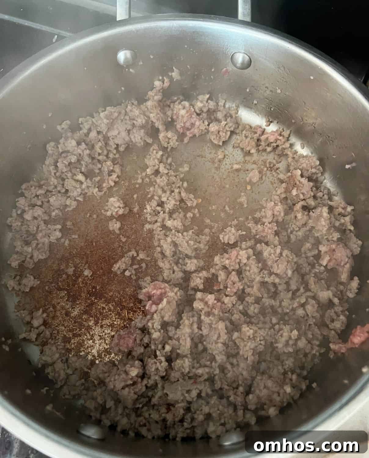 Sausage and kale cooked in a skillet.