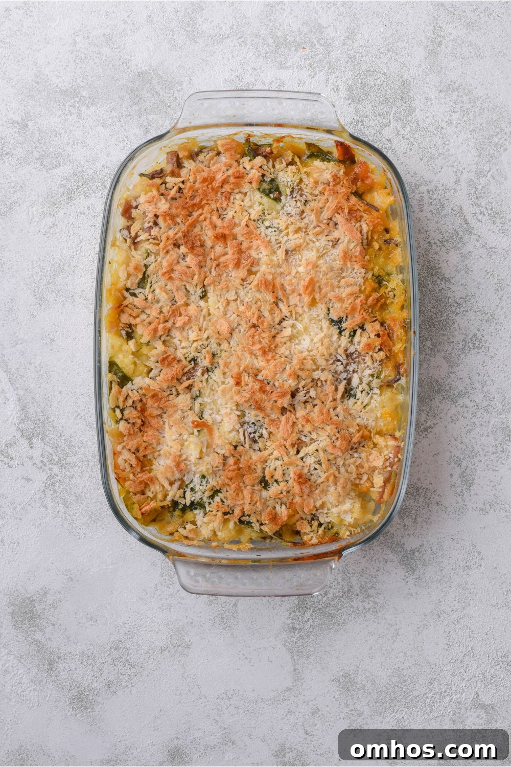 A baking dish filled with chicken cauliflower casserole covered in a layer of bread crumbs.