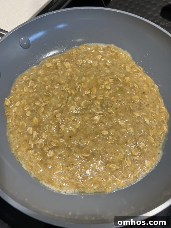 Scrambled oats sitting in pan on the stove.