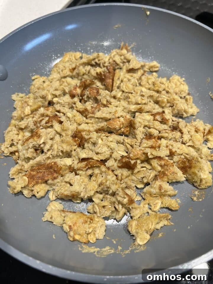 Scrambled oats sitting in a pan, completely cooked and scrambled.