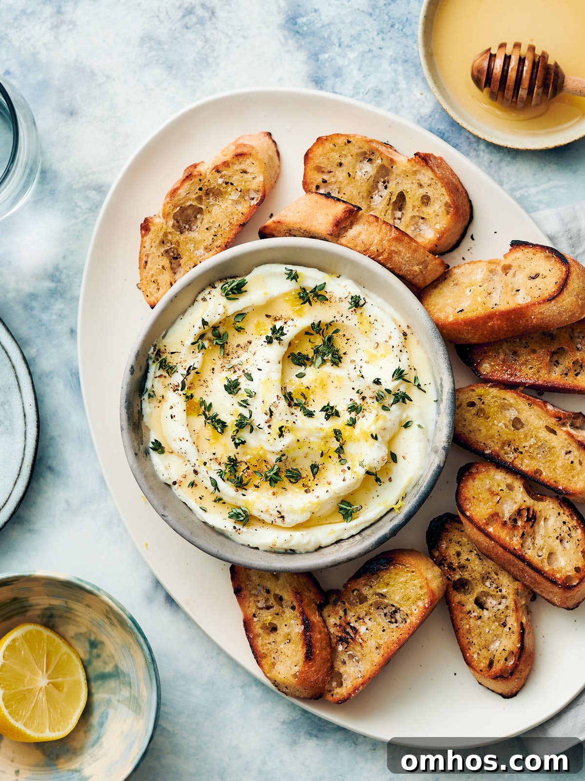 Creamy Whipped Ricotta Dip with Honey 8 Whipped ricotta dip with honey in a bowl being served with toasted bread.