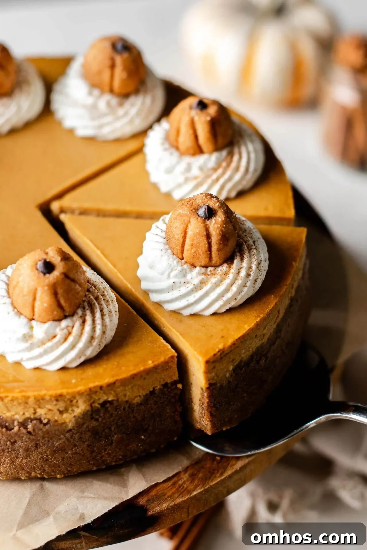 Creamy Pumpkin Cheesecake Recipe 2 sliced pumpkin cheesecake on wooden cake stand