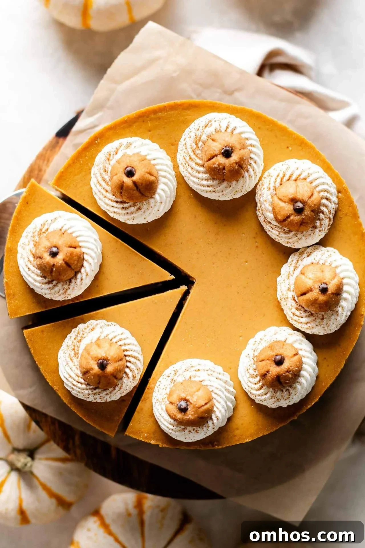 Creamy Pumpkin Cheesecake Recipe 5 overhead image of sliced pumpkin cheesecake on wooden cake stand