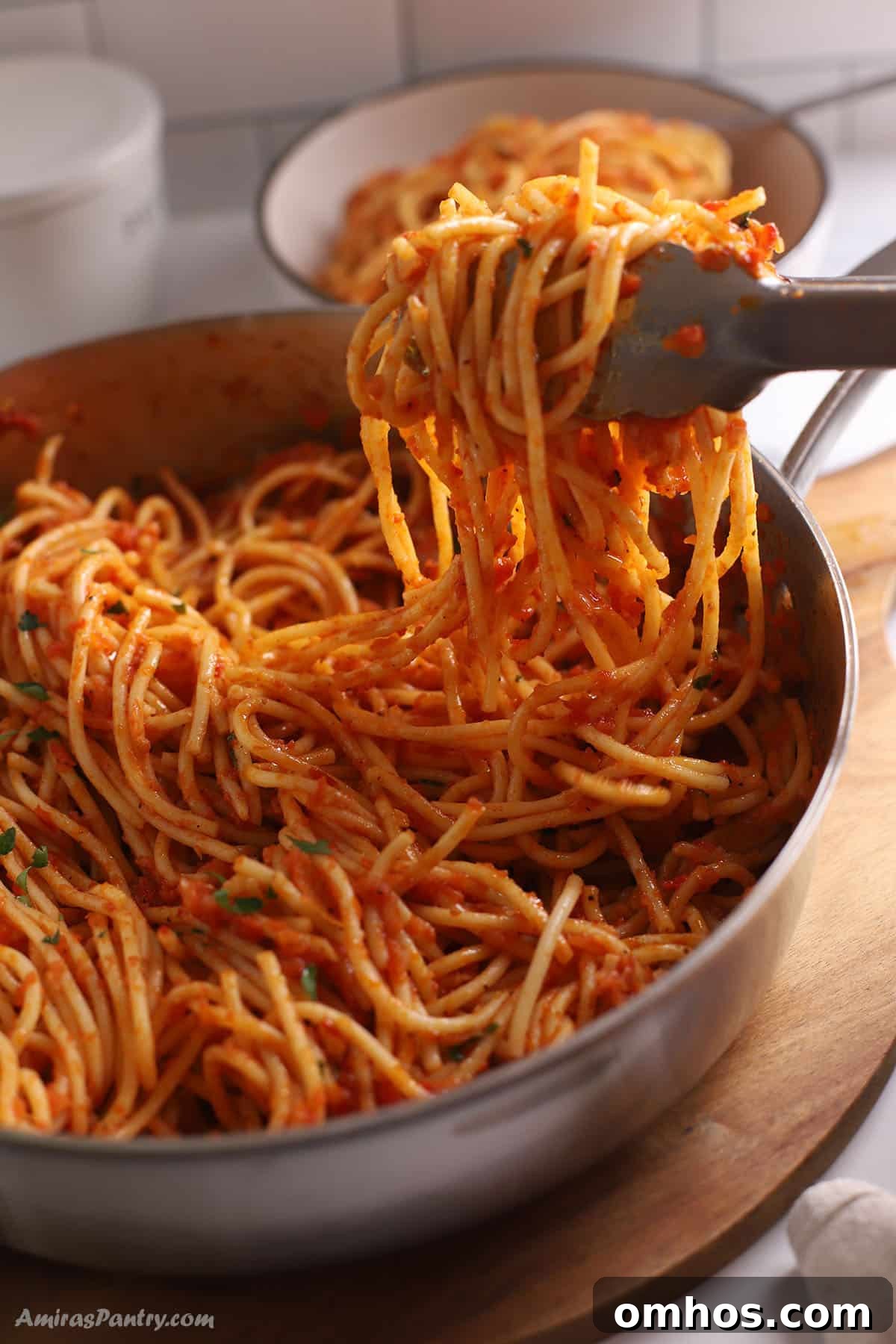 Kitchen tongs with harissa pasta.