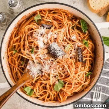 An overhead image of a large pot of pasta garnished with cheese.