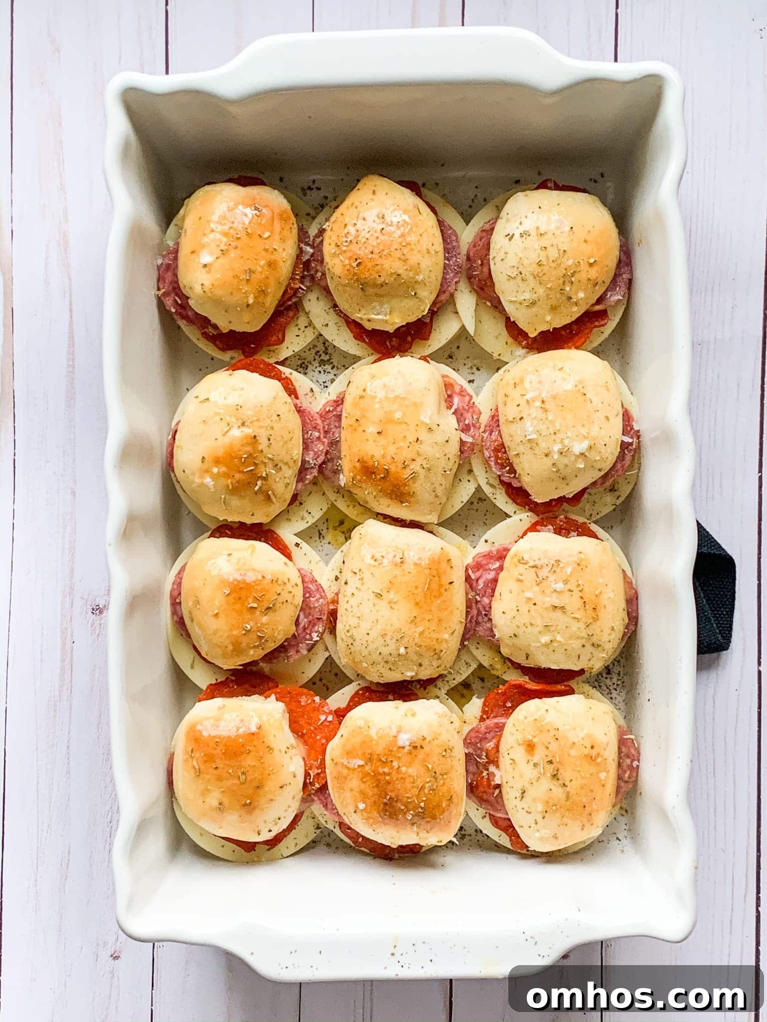 Baked Italian sliders in a white baking dish.