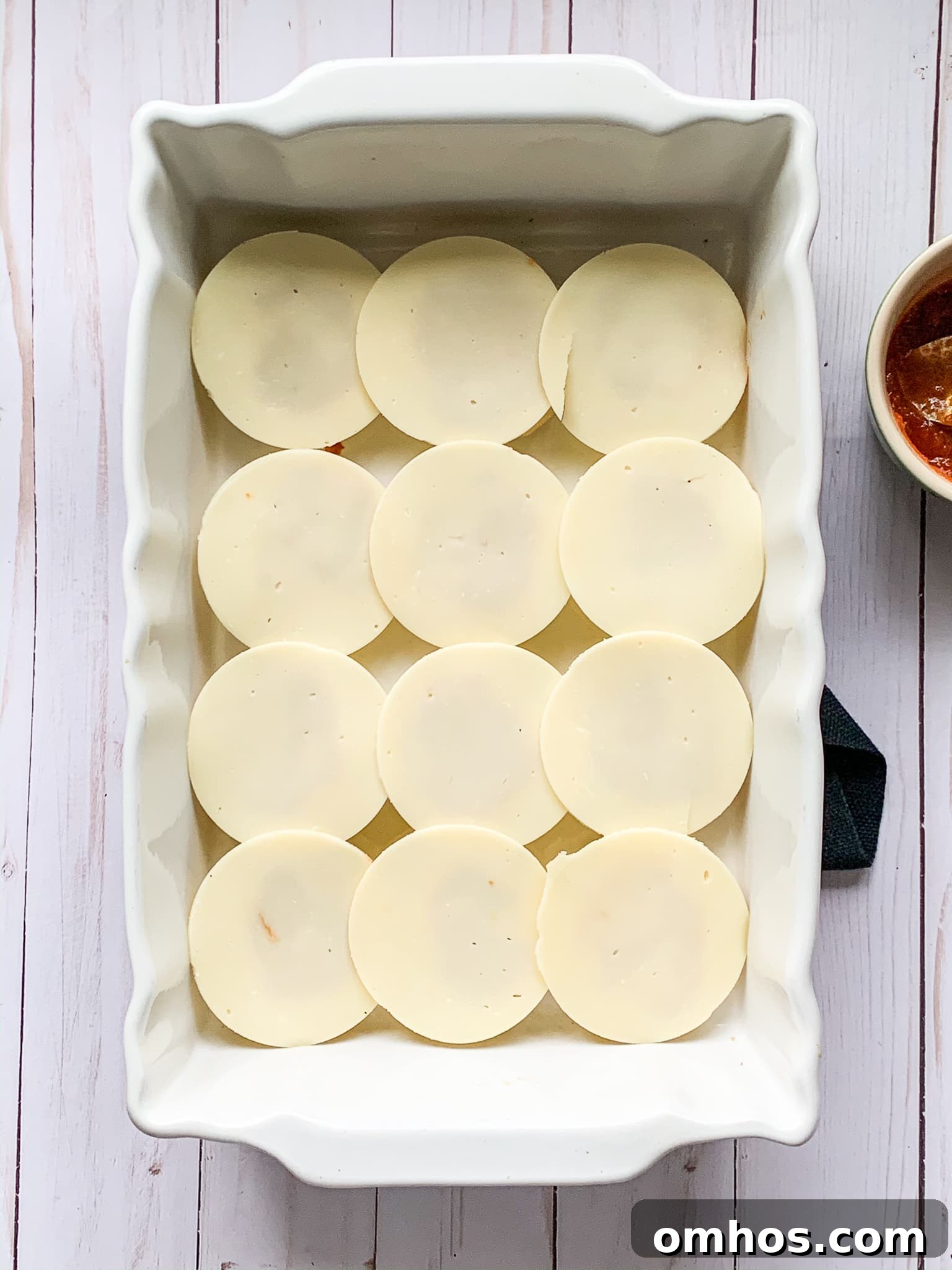 provolone cheese on top of game day sliders inside a baking dish.
