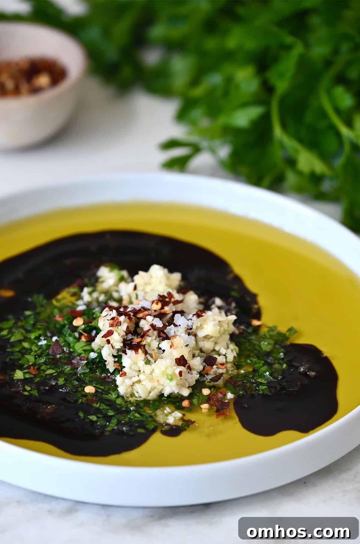Olive oil, balsamic vinegar, minced garlic, crushed red pepper flakes and finely chopped parsley in a shallow plate.