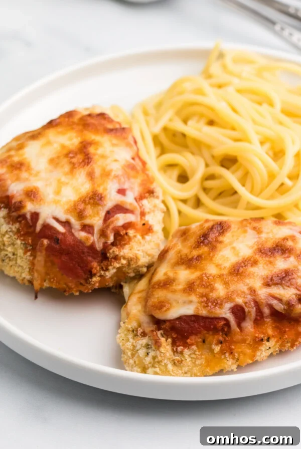 Crispy Air Fryer BBQ Ribs Recipe with Sticky Glaze 9 Air Fryer chicken parmesan on a white plate with spaghetti noodles.
