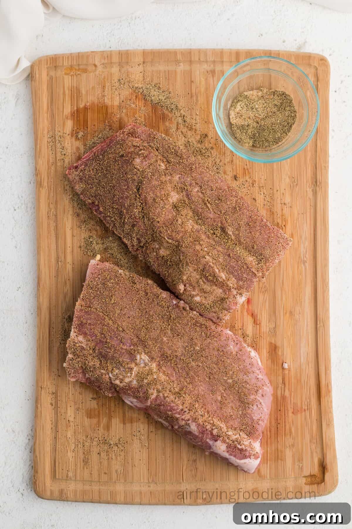 Crispy Air Fryer BBQ Ribs Recipe with Sticky Glaze 6 Seasoned ribs on a cutting board.