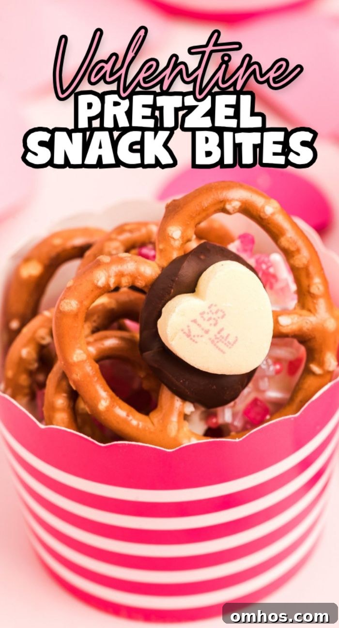 Valentine Pretzel Snack Bites Recipe 19 A striped pink cup holds Valentine Pretzel Snack Bites—pretzels topped with chocolate and a heart-shaped candy—for a festive Valentine’s Day treat.