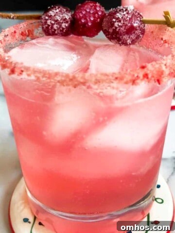 cranberry orange margarita with candied cranberry garnish