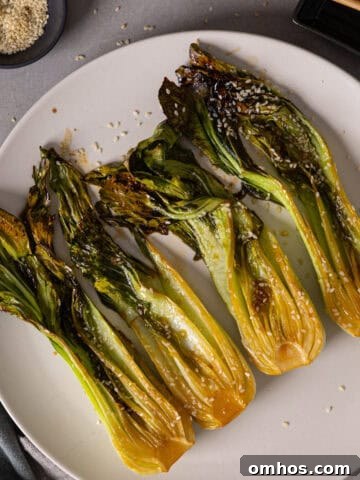 A platter of roasted bok choy lightly browned and garnished with sesame seeds.