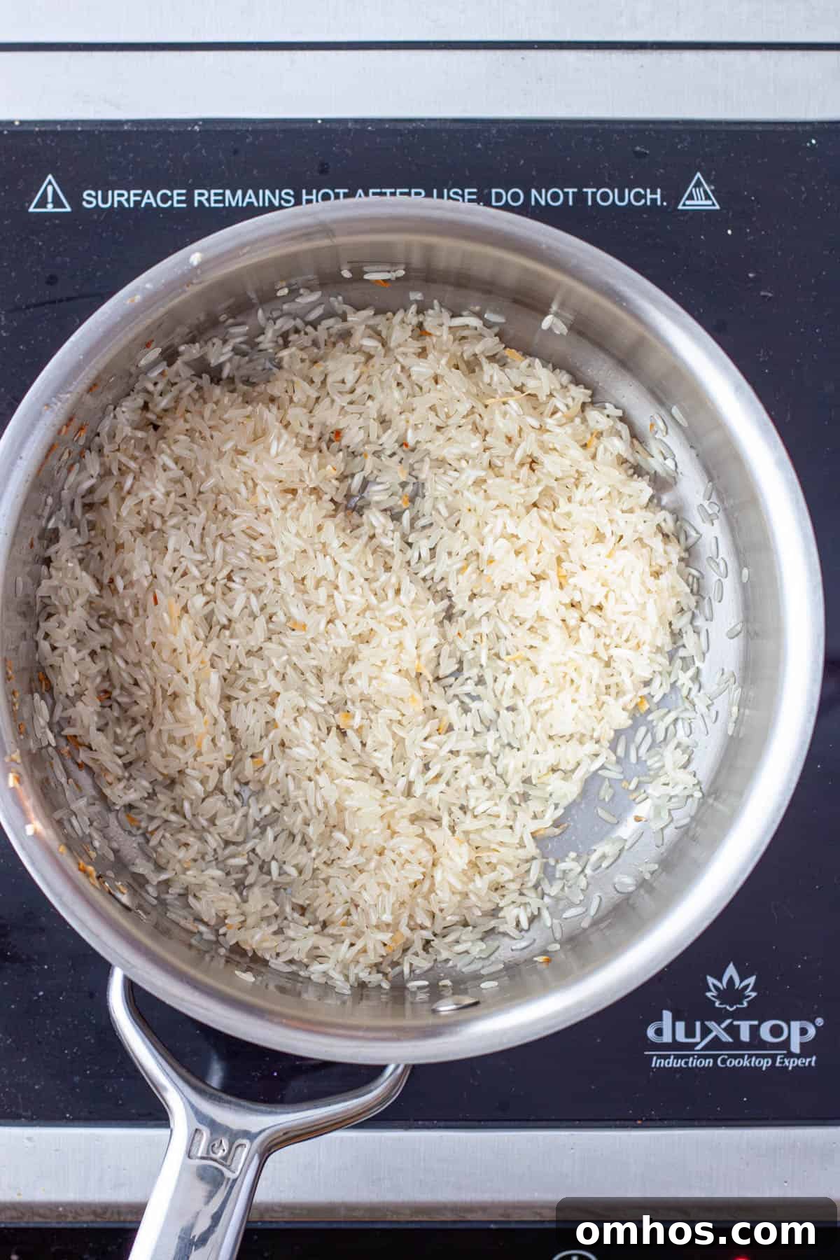 Fragrant Coconut Cilantro Rice Recipe 5 White rice toasting in a medium saucepan.