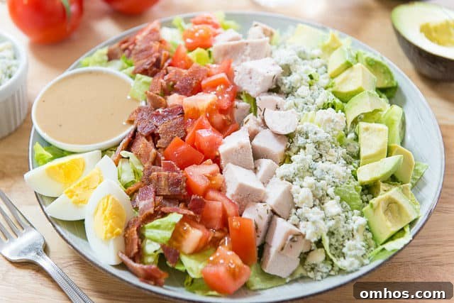 Classic Cobb Salad with Bacon, Avocado and Blue Cheese 7 A Visual of What is a Cobb Salad - Layers of Fresh Ingredients in Rows on Bed of Romaine Lettuce