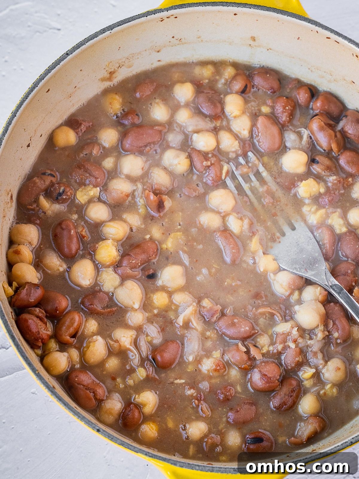 Mashing the beans with a fork.