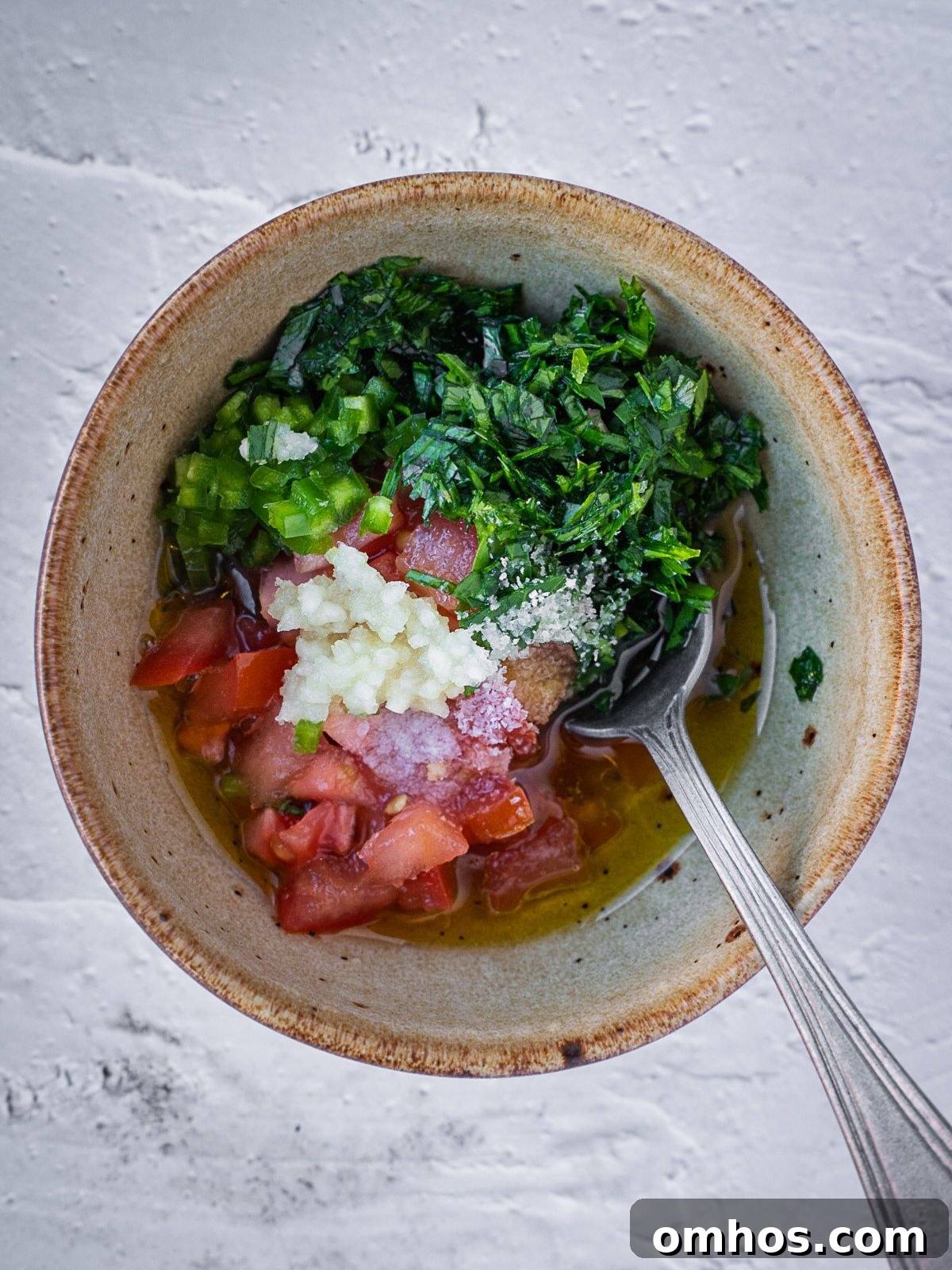 Bowl with chopped tomatoes, herbs and garlic.