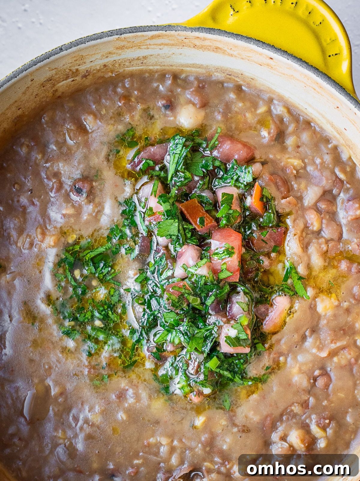 Adding the dressing to the pot of beans.